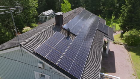 Aerial view circling reflecting PV modules on a self-sufficient, off-grid house
