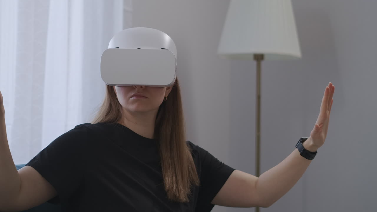 una joven está usando la tecnología contemporánea de la realidad virtual usando auriculares vr y viendo imágenes y video usando movimientos de las manos para hacer zoom