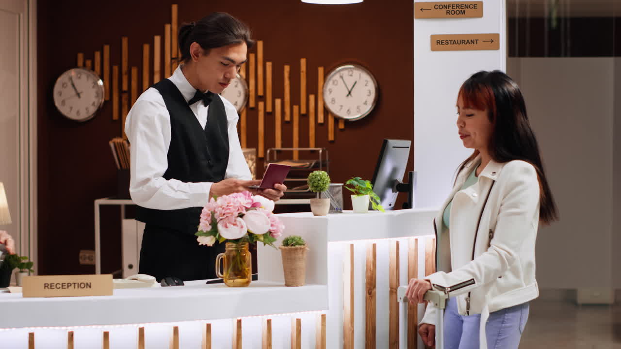 el personal de la recepción está viendo la información de identificación en el pasaporte.