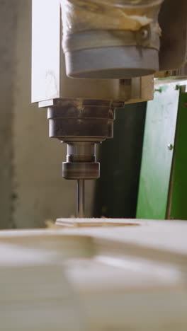 router cnc en acción en madera contrachapada en capas, entorno de taller con fondo de máquina verde
