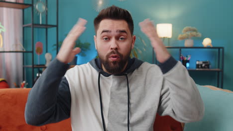 excited caucasian man surprised shocked by sudden victory good win news celebrating wow reaction