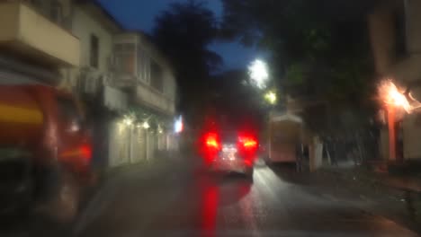 view of road on a rainy day through the windshield of car, wiper cleaning the windshield