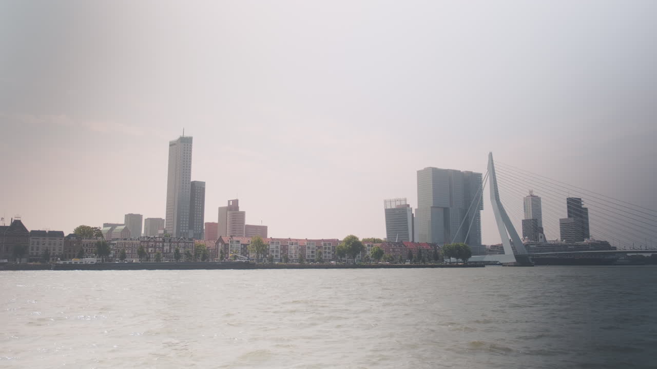 Erasmusbrug AKA The Swan during the day with skyscrapers and cityscape in Rotterdam, Netherlands, wide shot