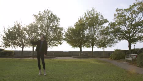 Woman-walking-in-a-park-talking-on-videocall-on-her-phone