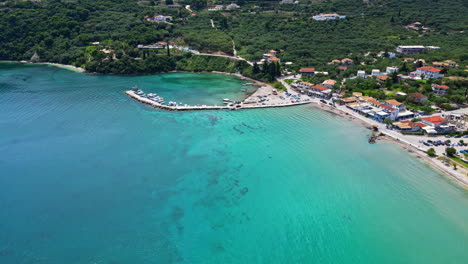 Agios Sostis Turquoise beach bay, white sand Greek landscape, aerial drone fly travel destination, green hills and resorts