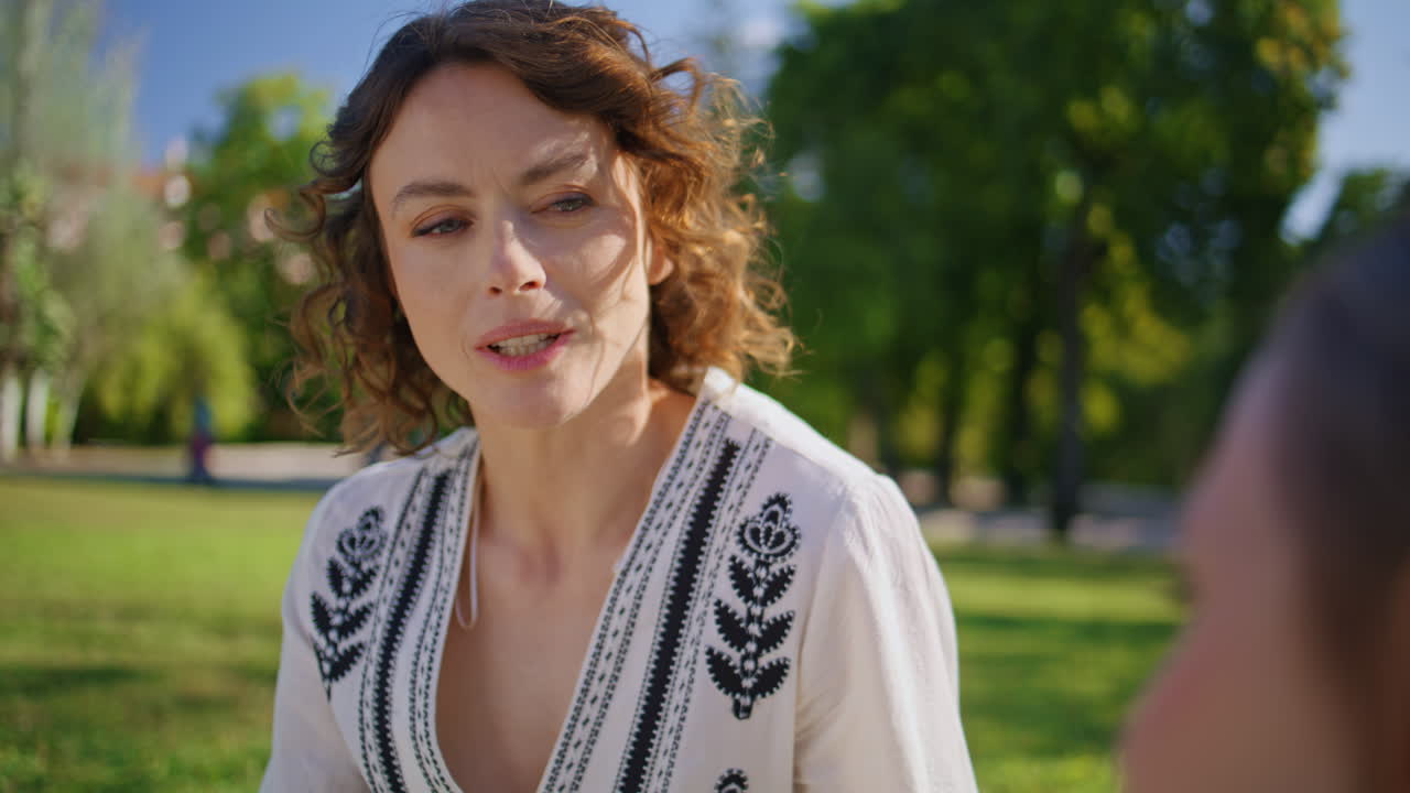 Joyful mother speaking daughter on summer picnic closeup. Woman looking girl