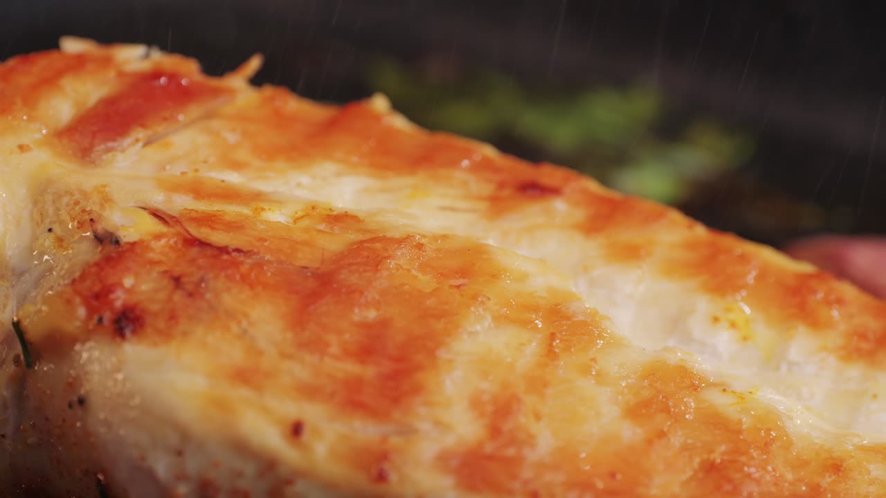 Cooking raw chicken meat in yellow turmeric spice with garlic and greens on grill close-up. Fry chicken slice on frying.pan Grilled chicken, duck, turkey kebab with vegetables.