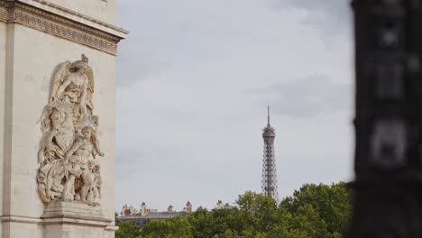 arc de triomphe sculpture with eiffel tower in background