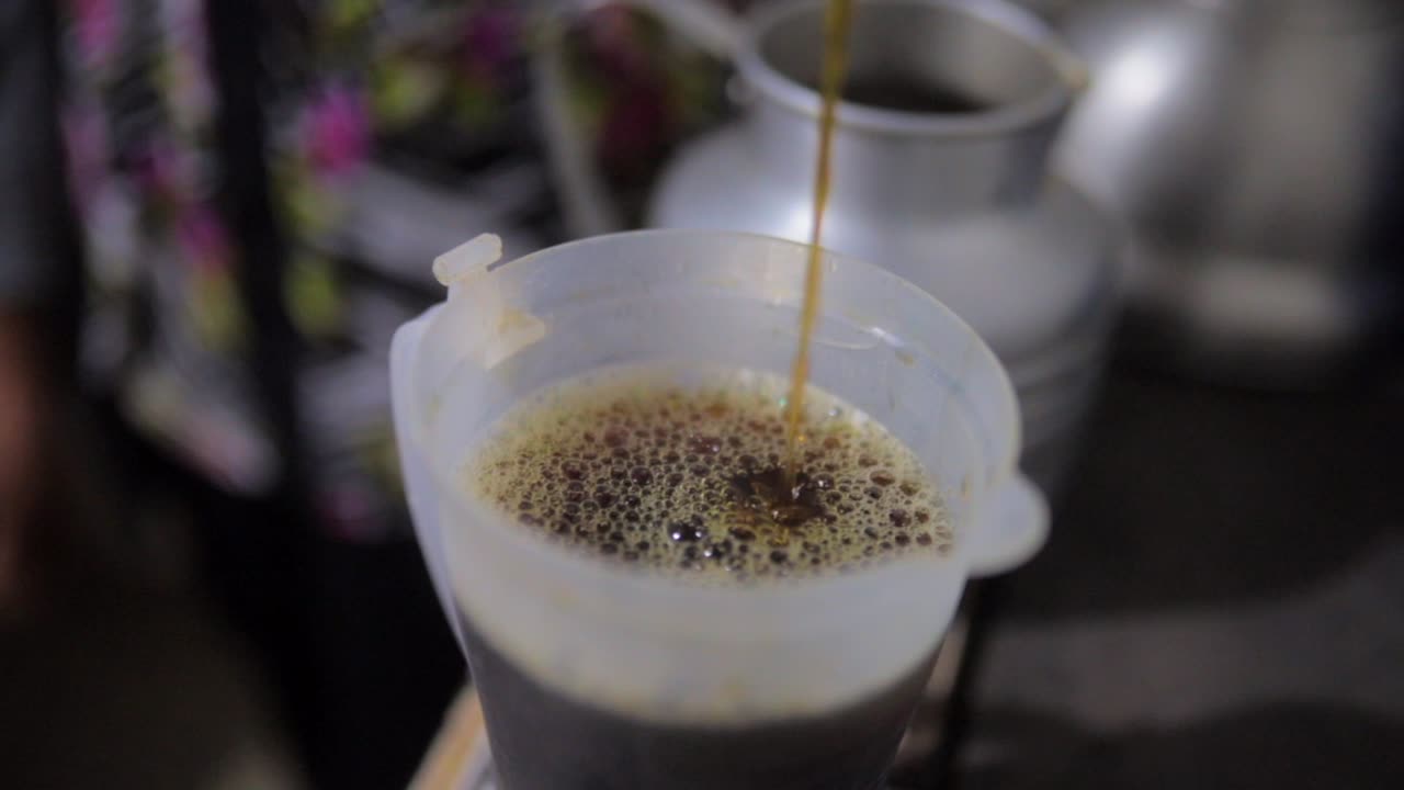 Hot coffee pouring in a cup in Central America rural kitchen