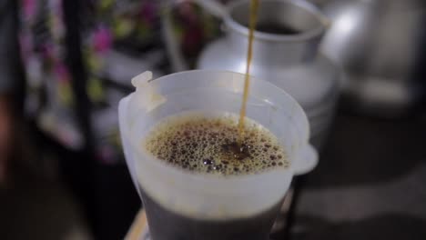 hot coffee pouring in a cup in central america rural kitchen