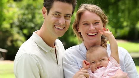 padres felices con su niña en el parque