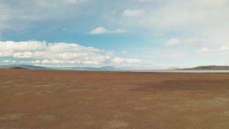 lone traveller waking in the patagonian steppe, argentina.
aerial view of adventurous explorer alone in the wilderness.
panoramic view of brown ground and cloudy blue sky.