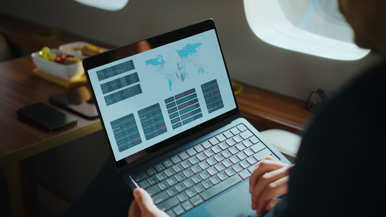 Businessman Analyzing Financial Data on Laptop in Private Jet