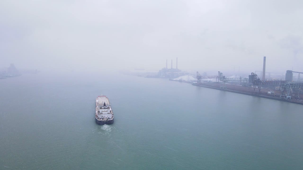 Steel Barge Navigating Foggy Detroit River past Zug Island Steel Mill