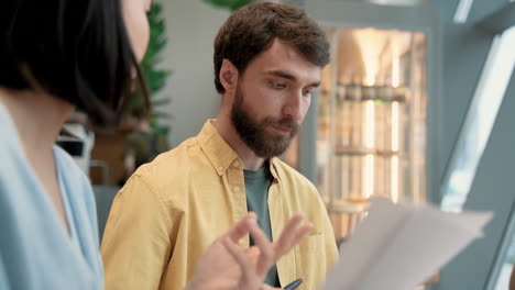 a male has a business meeting in a coffe shop with an young female