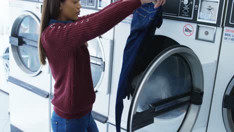 mujer quitando la ropa de la lavadora 4k