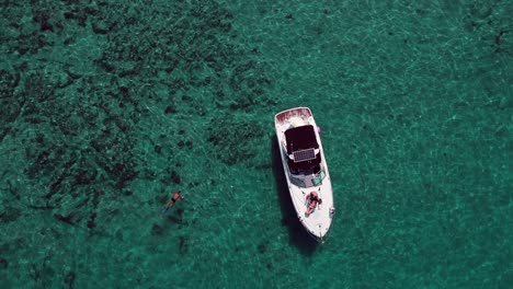 disparo de un dron desde arriba de un hombre buceando cerca del barco