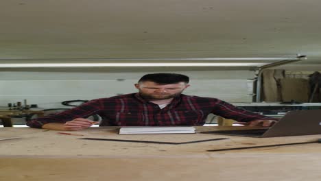 carpintero tomando notas en el taller