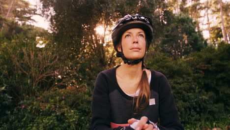 female mountain biker standing with bicycle looking up