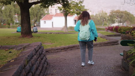 una mujer caminando por un parque.