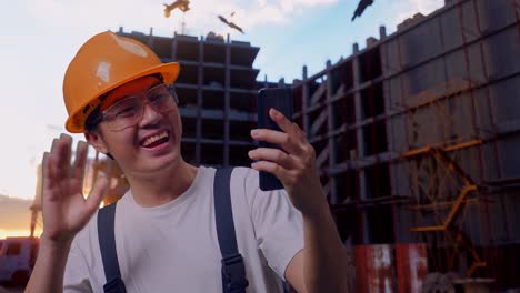 asian man worker having a video call on smartphone at construction site