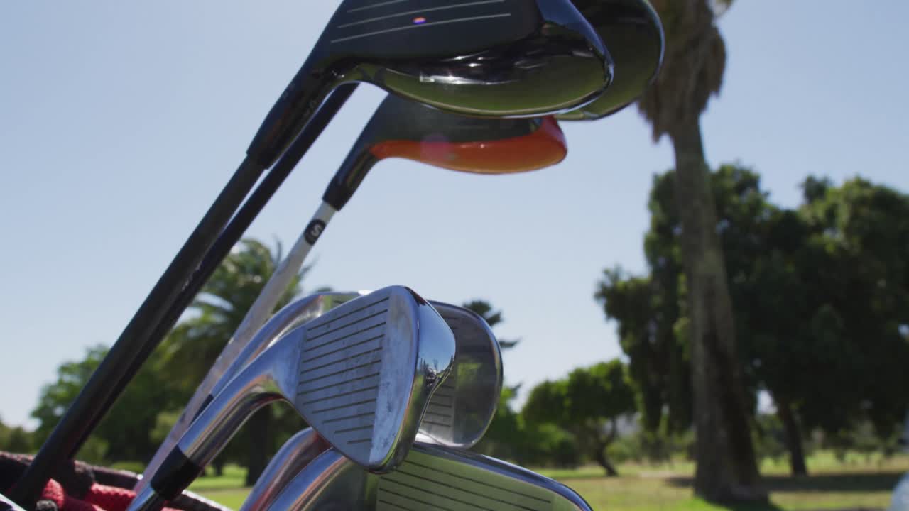Close-up van meerdere golfclubs in een golftas op de golfbaan op een heldere zonnige dag.