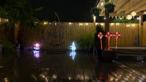 imágenes al aire libre de un jardín minimalista por la noche con iluminación cálida, luces de hadas y decoraciones navideñas