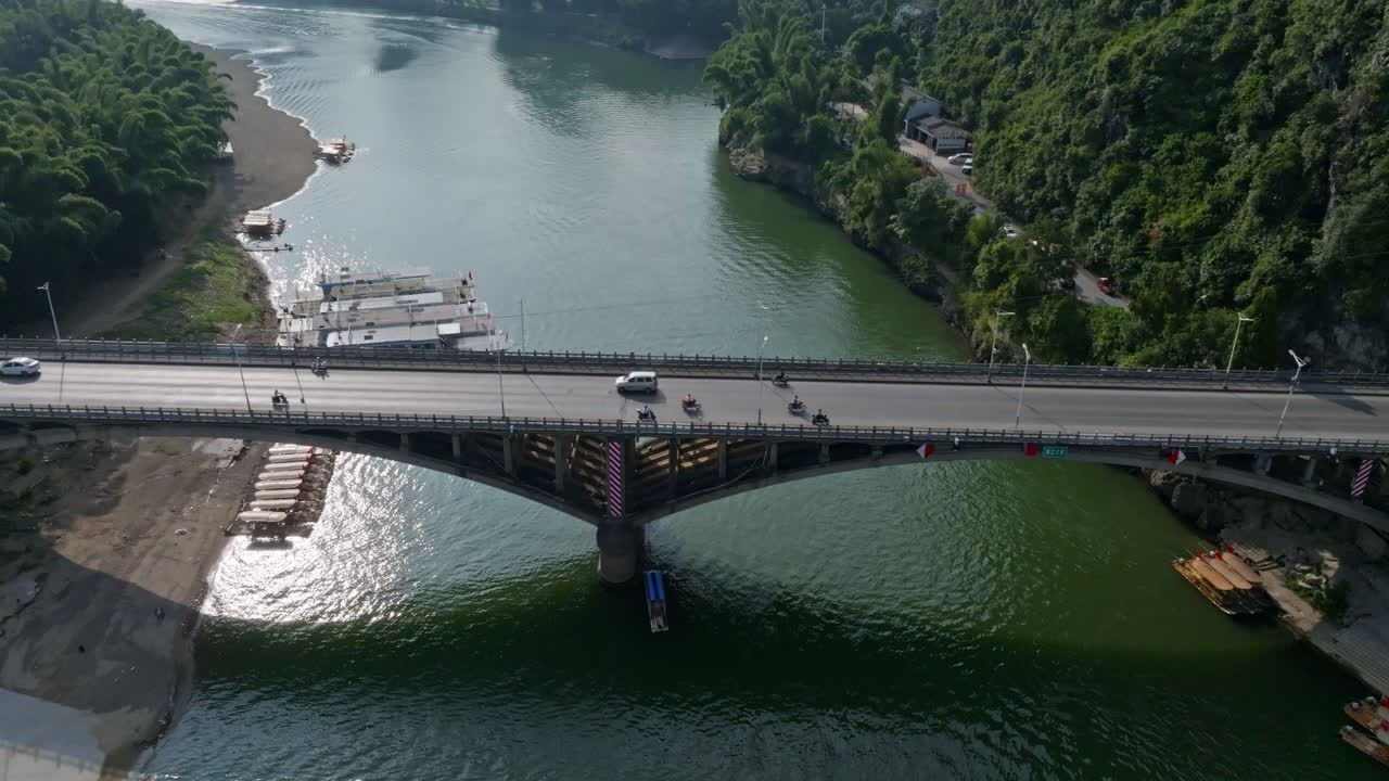 Aerial tracking shot of traffic on the Yangshuo bridge, summer in Guangxi, China