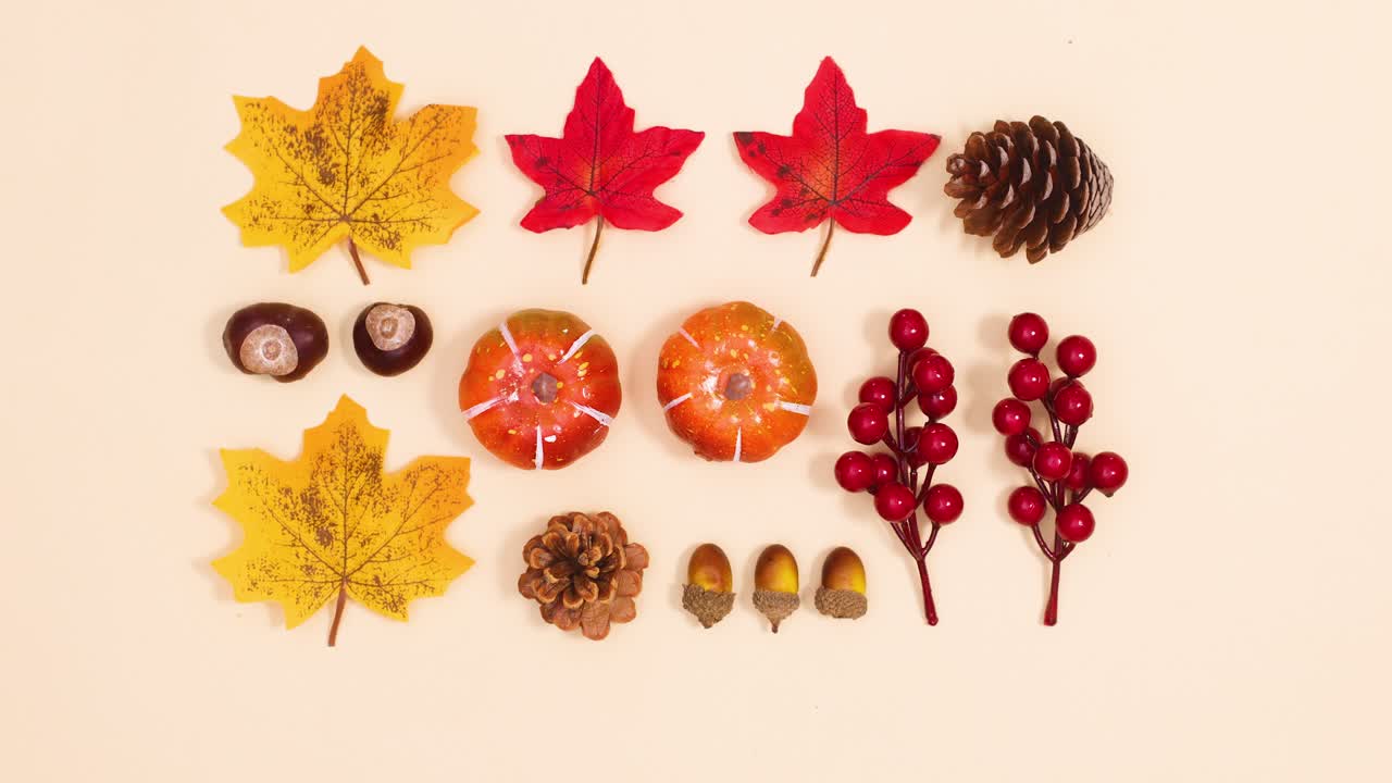 Creative autumn layout made of leaves and autumn fruits move on beige theme. Stop motion