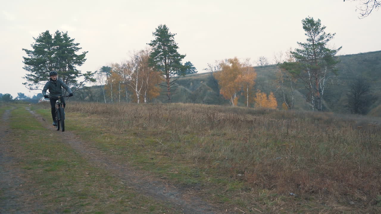 시골 길을 따라 산악 자전거를 타는 남성 자전거 타는 사람