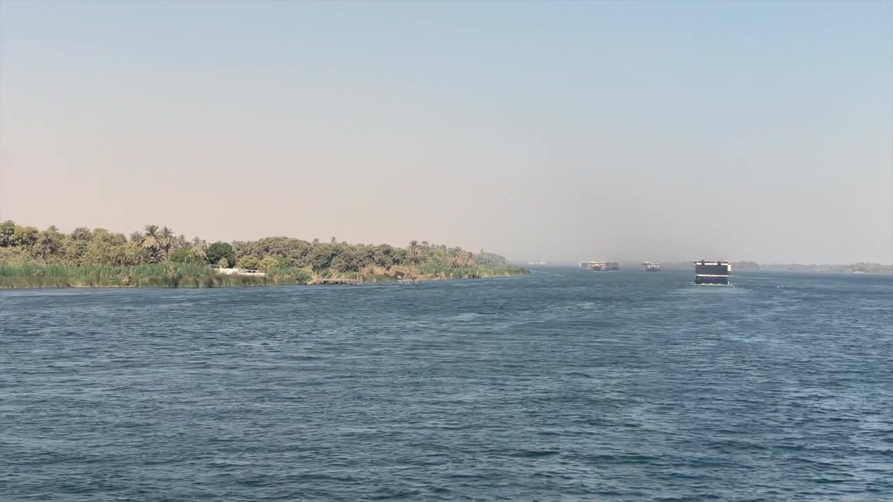 VISTA POSTERIORE DI UNA NAVE DA CROCIERA CHE NAVIGA LUNGO IL FIUME NILO IN EGITTO. RIVA