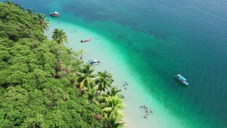 drone forward shot of estrella beach and some boats located in the caribbean sea in bocas del toro, panama