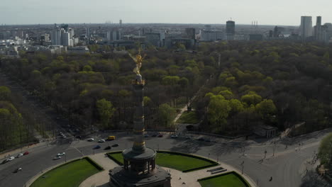 AERIAL:-Wide-View-Circling-around-Berlin-Victory-Column-Golden-Statue-Victoria-in-Beautiful-Sunlight-and-Berlin,-Germany-Cityscape-Skyline-in-Background