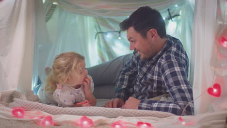 Padre-E-Hija-Pequeña-Con-Libro-Para-Colorear-En-Un-Campamento-Casero-En-El-Dormitorio-De-Un-Niño-En-Casa---Filmados-En-Cámara-Lenta