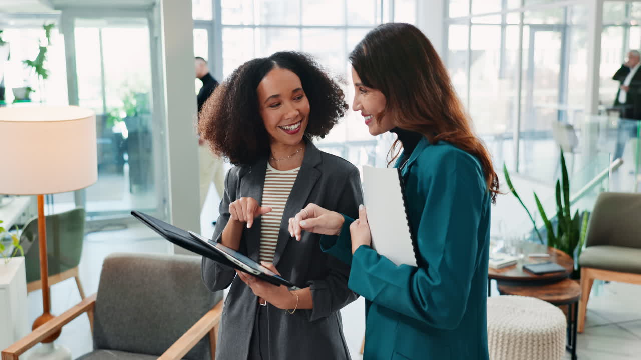 Two Businesswomen Discuss a Project on a Tablet in an Office Setting