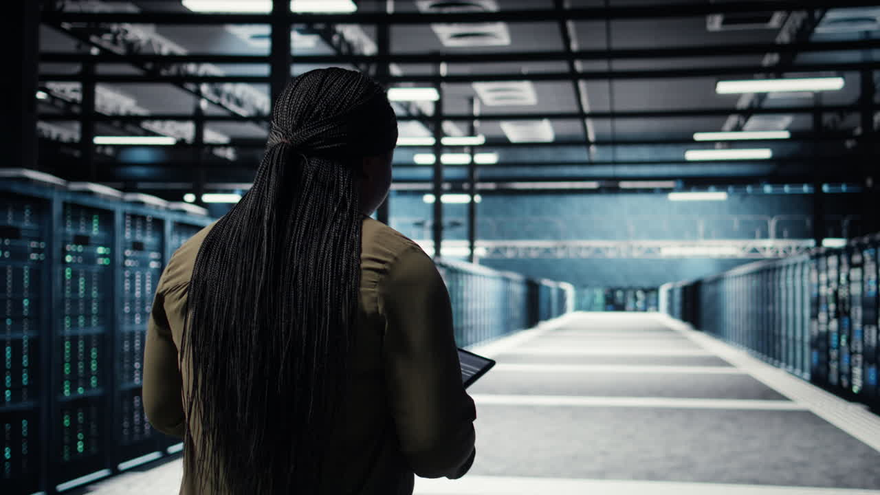 Data center system administrator monitors data center metrics on tablet