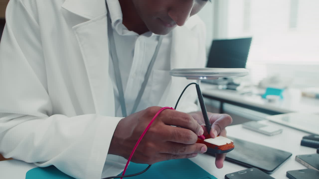 Repairman Using Multimeter when Fixing Broken Phone