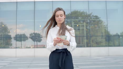 Woman-counting-cash-bills-in-her-hands,-handheld-closeup