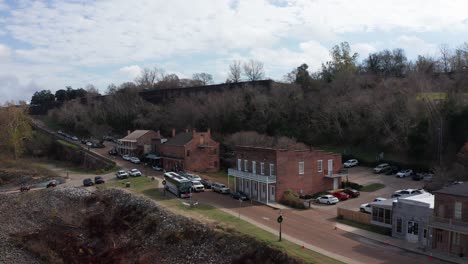 Toma-Aérea-De-Primer-Plano-Rodando-A-Lo-Largo-De-Natchez-Debajo-De-La-Colina-En-Natchez,-Mississippi