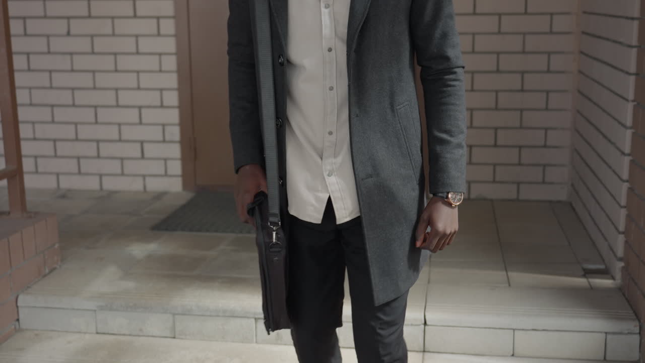 Primer plano de una mano oscura con venas visibles, con una correa de cuero y un reloj de pulsera metálico. Movimiento sutil al flexionar los dedos, la caja pulida reluce mostrando detalles masculinos e imagen de marca de estilo de vida.