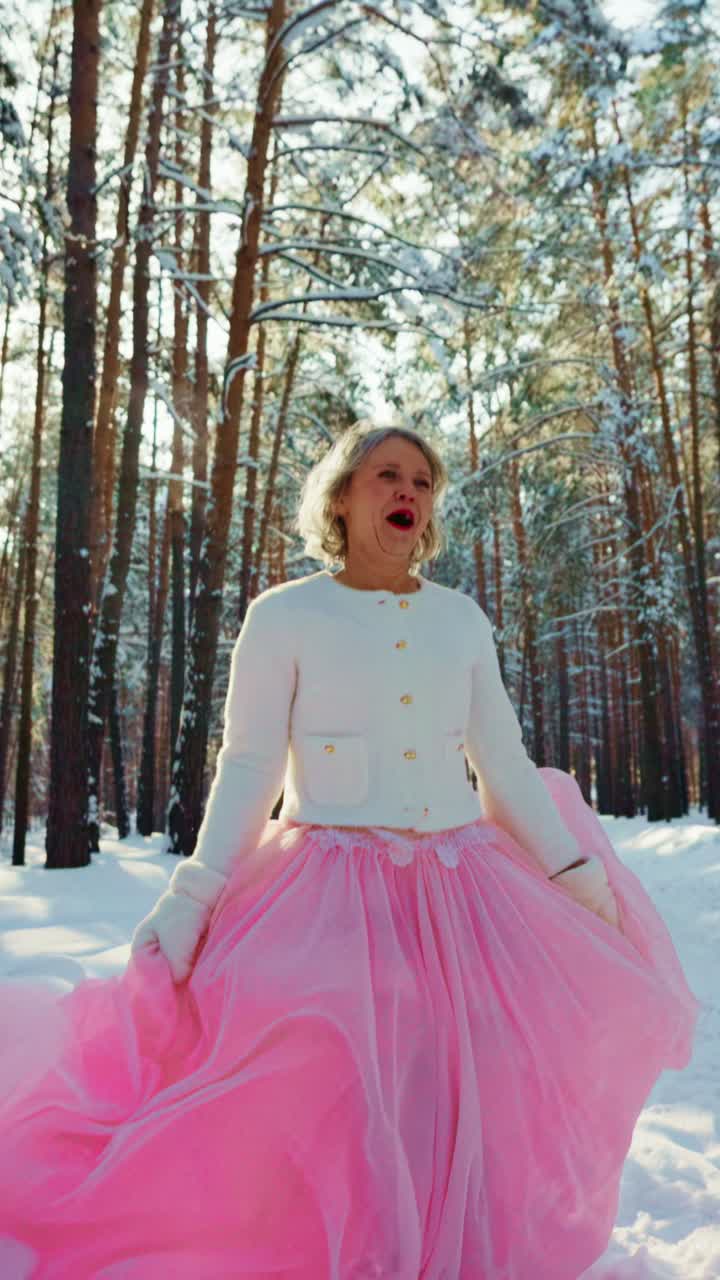Donna elegante in gonna rosa con emozioni mutevoli in una foresta innevata