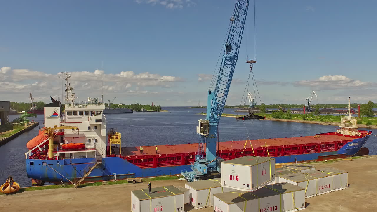 тяжелый кран, загружающий грузовое судно, вид с воздуха с беспилотника