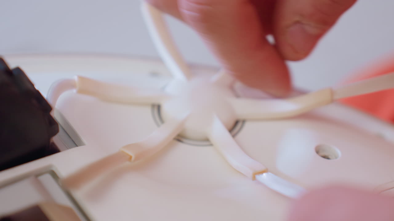 Extreme close up of hand adjusting side brush on robot vacuum during maintenance process showing detailed care for household appliance to ensure efficient cleaning, smooth operation