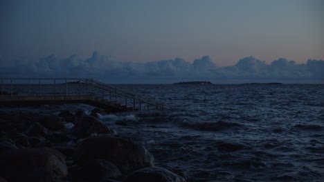 waves crashing on concrete stairs in the dusk