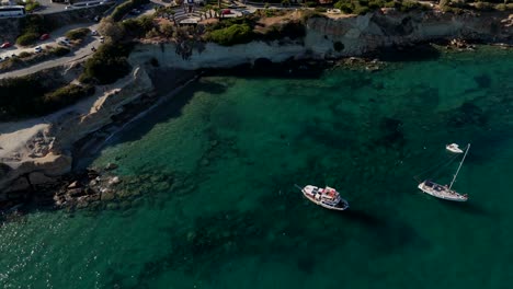 vista aérea de barcos anclados cerca de acantilados y aguas turquesas en la isla de creta, grecia