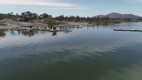 aerial: hovering drone shot of dock on a green lake