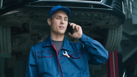 mecánico hablando por teléfono en el taller de reparación