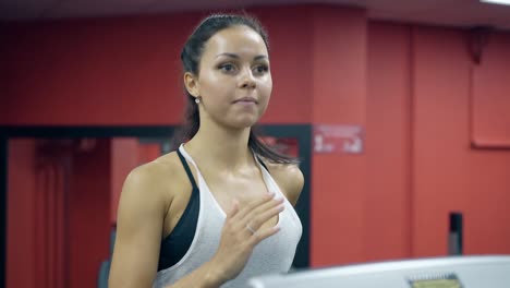 vista cercana chica enciende la cinta de correr y comienza a correr