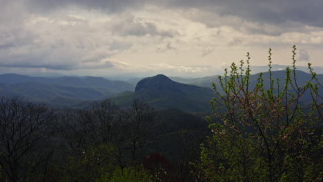 Rising-over-trees-revealing-Looking-Glass-Rock-in-North-Carolina-mountains