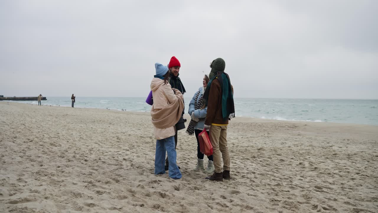 Friends talking on a winter beach